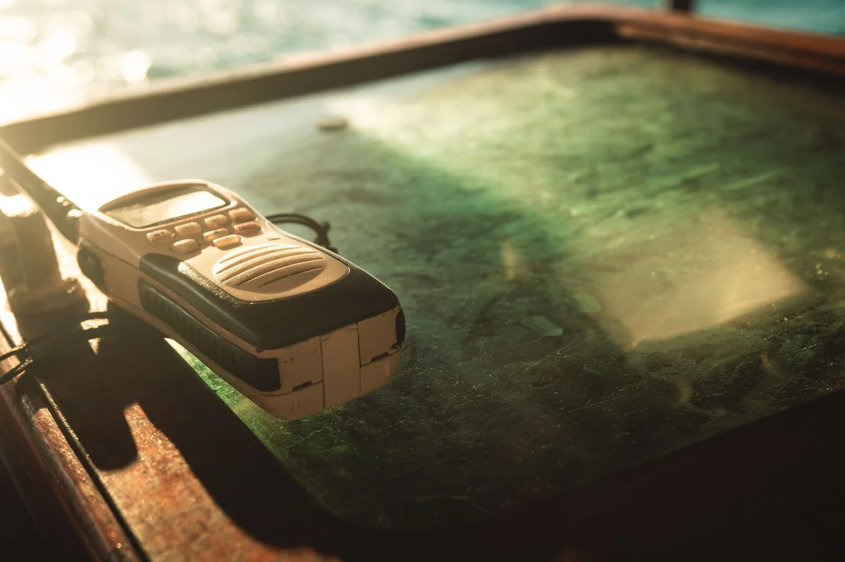 Handheld two-way radio on a table — emergency communication guide covering FRS and GMRS radios