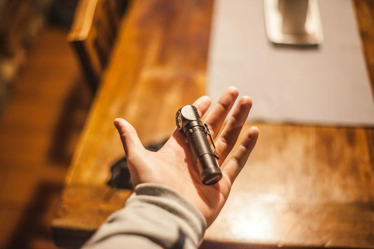Hand holding LED flashlight lighting the hallway during the Iberian blackout of April 2025 — 72-hour emergency kit in real use