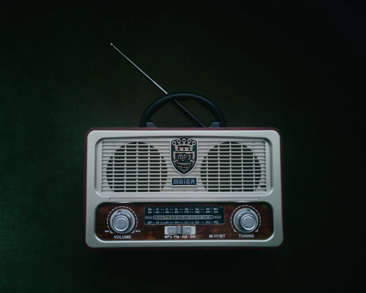 Radio AM/FM con antena extendida sobre superficie clara — radio de emergencia para captar bandas oficiales durante apagón