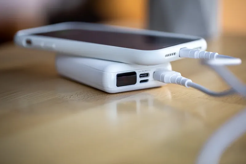 Powerbank a carregar um smartphone para manter os alertas de emergência durante um apagão