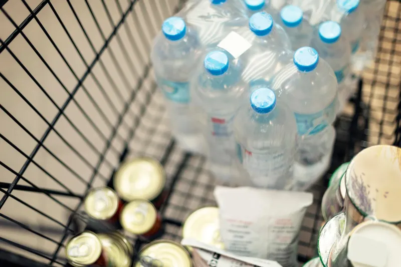 Reserva de alimentos de emergencia con conservas, agua embotellada y productos no perecederos para preparación insular